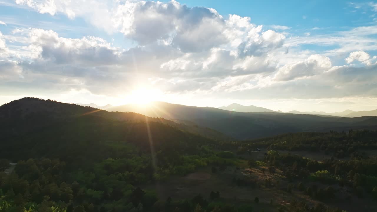 Aerial view of a wide, open rocky mountain valley with surrounding hills and green fields in Boulder, Colorado