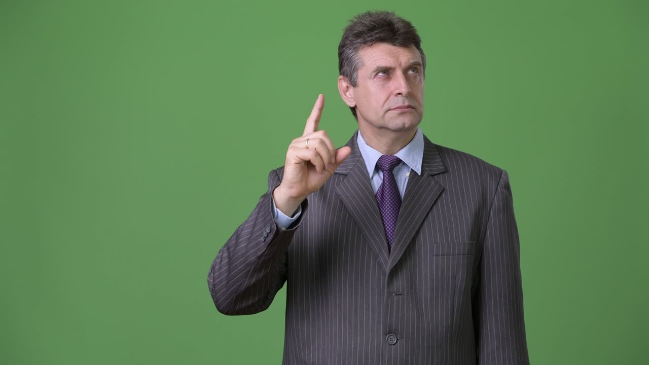 Uomo d'affari maturo e affascinante su sfondo verde