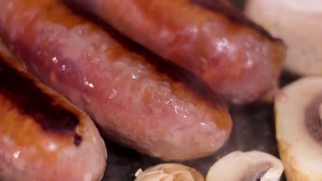 sausages and mushrooms cooking on a grill