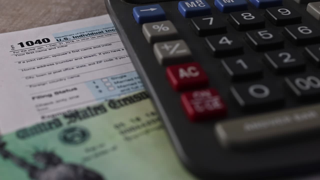 1040 Tax form with refund check and currency US dollar banknotes close-up