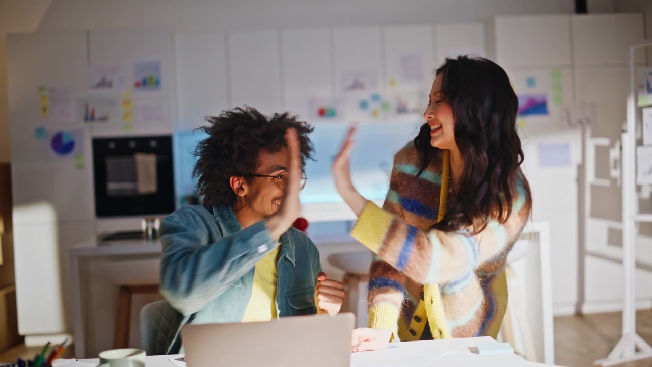 Business partners high five celebrating good news. Phone call home office team.