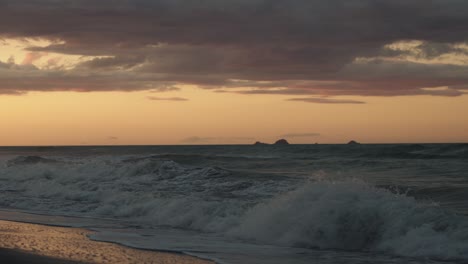 Un-Hermoso-Cielo-Naranja-Durante-El-Amanecer-En-Una-Playa-En-Nueva-Zelanda