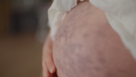pregnant woman stroking belly close-up eighth month