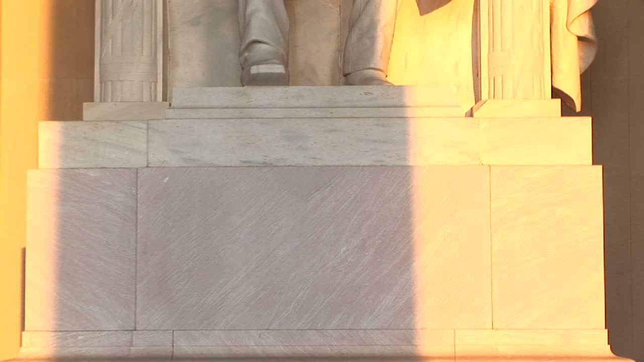 luz dorada se derrama sobre una estatua del presidente lincoln 1