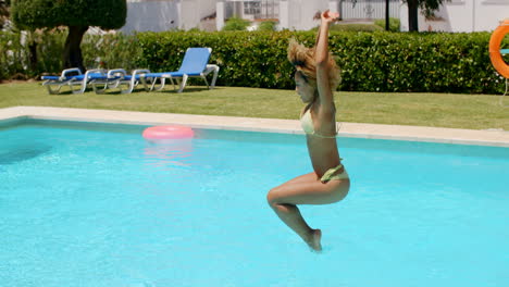 chica feliz saltando a la piscina