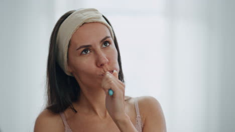 en primer plano, una chica despreocupada cepillándose los dientes en el baño. una mujer bailando cepillarse los dientes.