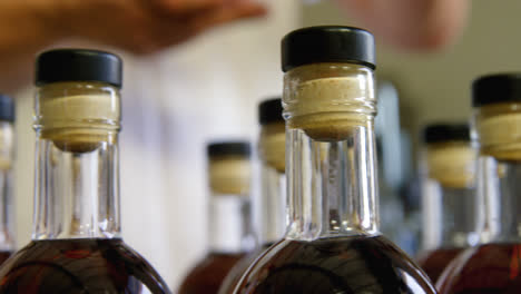 male worker arranging liquor bottles in factory 4k