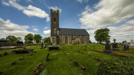 lapso de tiempo del cementerio histórico y la iglesia medieval en la irlanda rural con nubes pasajeras y sol