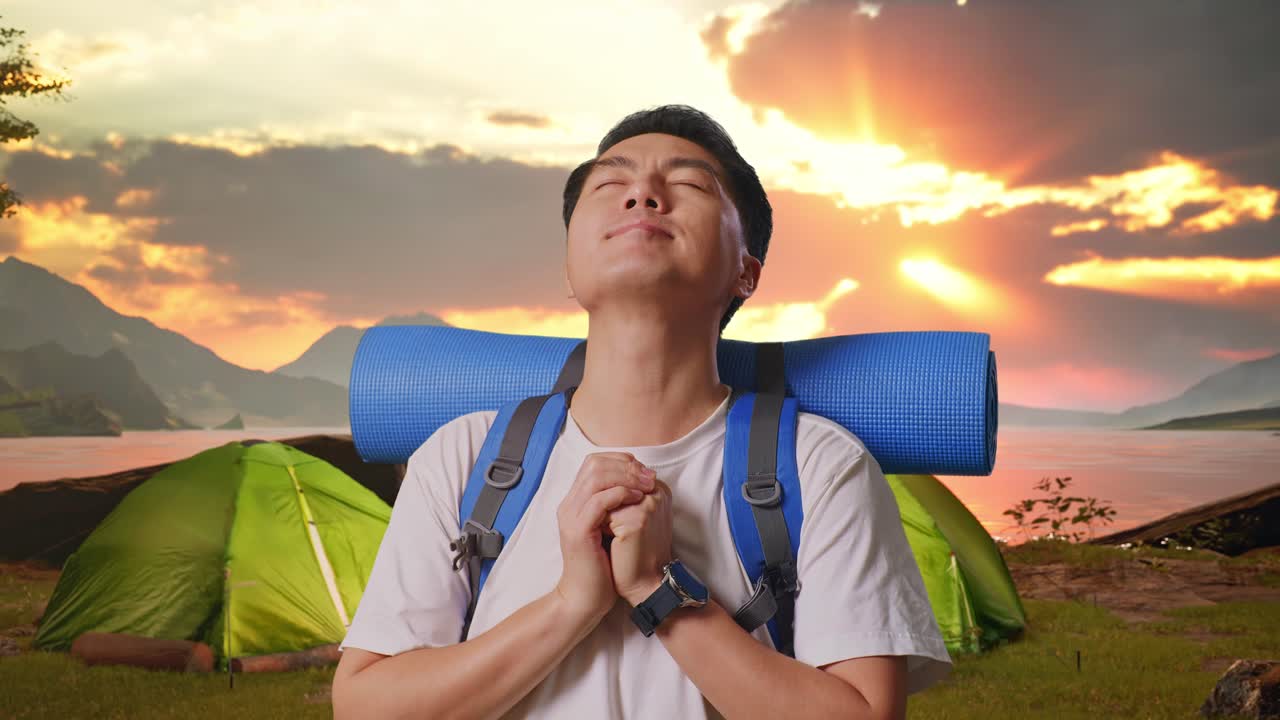 Man Praying While Camping at Sunset