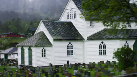 lentitud de disparo más allá de una iglesia y un cementerio en el campo de vestlands, noruega