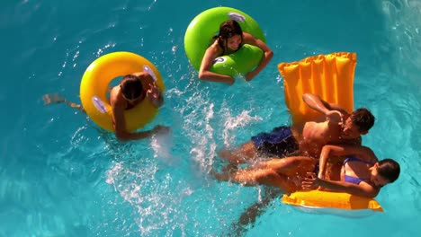 Amigos-Divirtiéndose-Y-Chapoteando-Juntos-En-La-Piscina