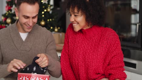 vista de mano de una pareja feliz abriendo un regalo de navidad