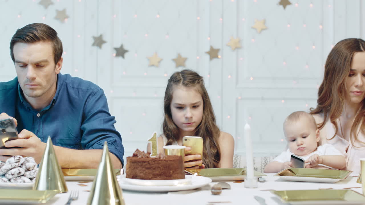 personas serias viendo dispositivos móviles después de la celebración del cumpleaños en una casa de lujo