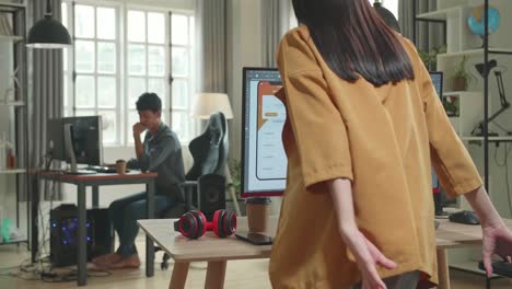back view of asian female mobile application developer start works with graphics on her personal computer in office