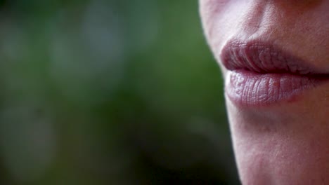 un primerísimo plano de una bella mujer fumando un cigarrillo al aire libre