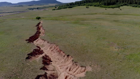 Vistas-Aéreas-De-Un-Avión-Cubierto-De-Hierba-Que-Se-Dirige-A-Una-Hermosa-Formación-Rocosa-En-Palmer-Lake-Colorado