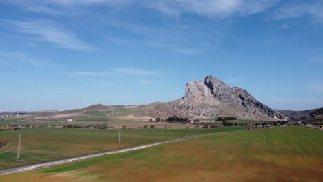 Spectacular-aerial-flight-over-the-enclave-of-Peña-de-los-Enamorados,-a-rock-formation-in-the-shape-of-a-human-face-in-the-municipality-of-Antequera-in-Andalusia,-Spain