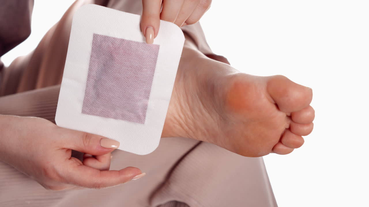 primer plano de una tira de cera aplicada en el talón de una mujer para la depilación