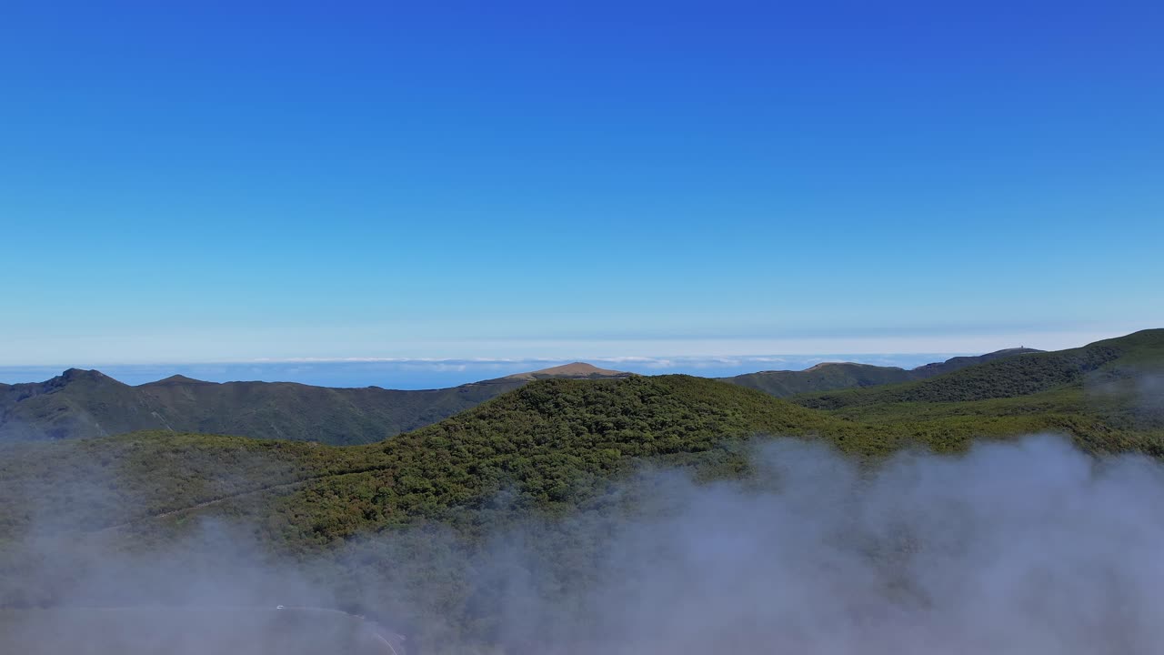 Scenic aerial view of Madeira's misty mountains under a clear sky