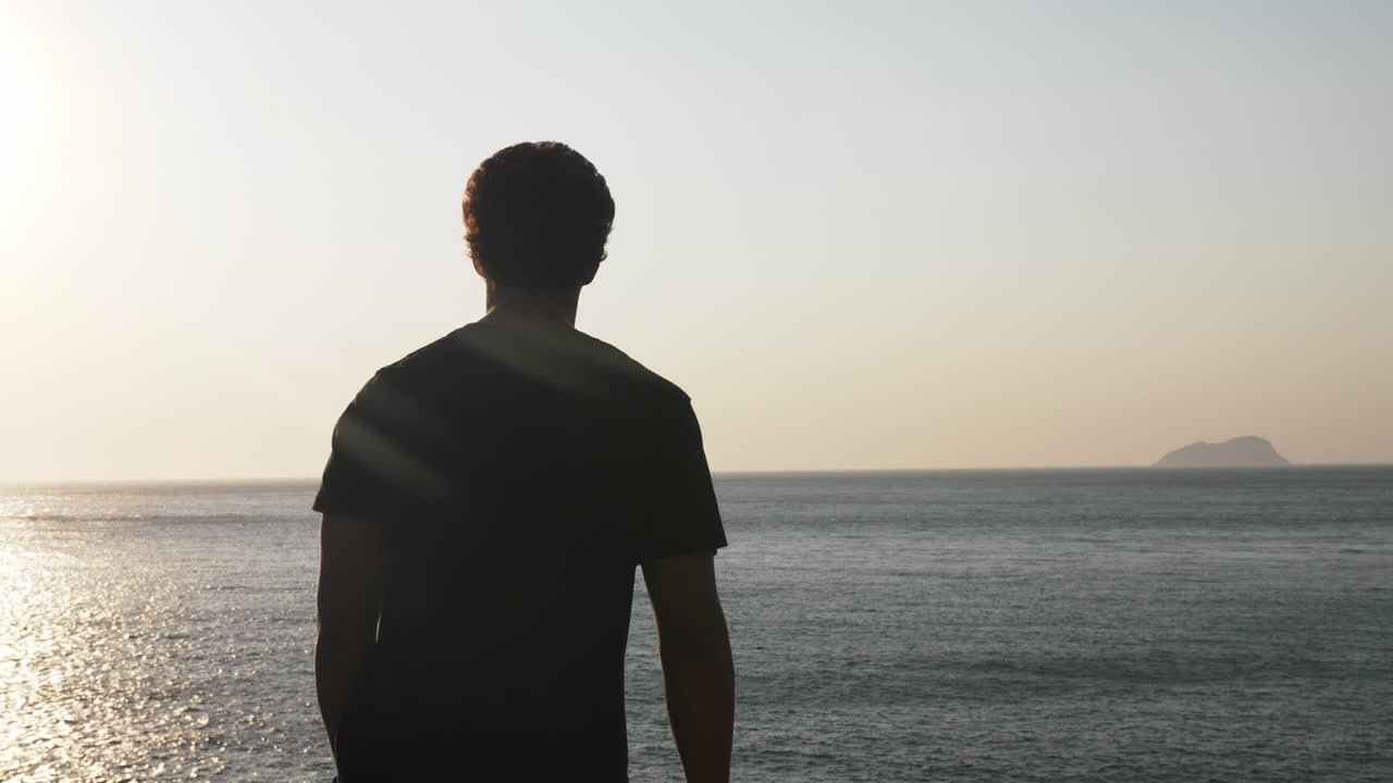Silhouette Man Walking on Sea Cliff at Sunset