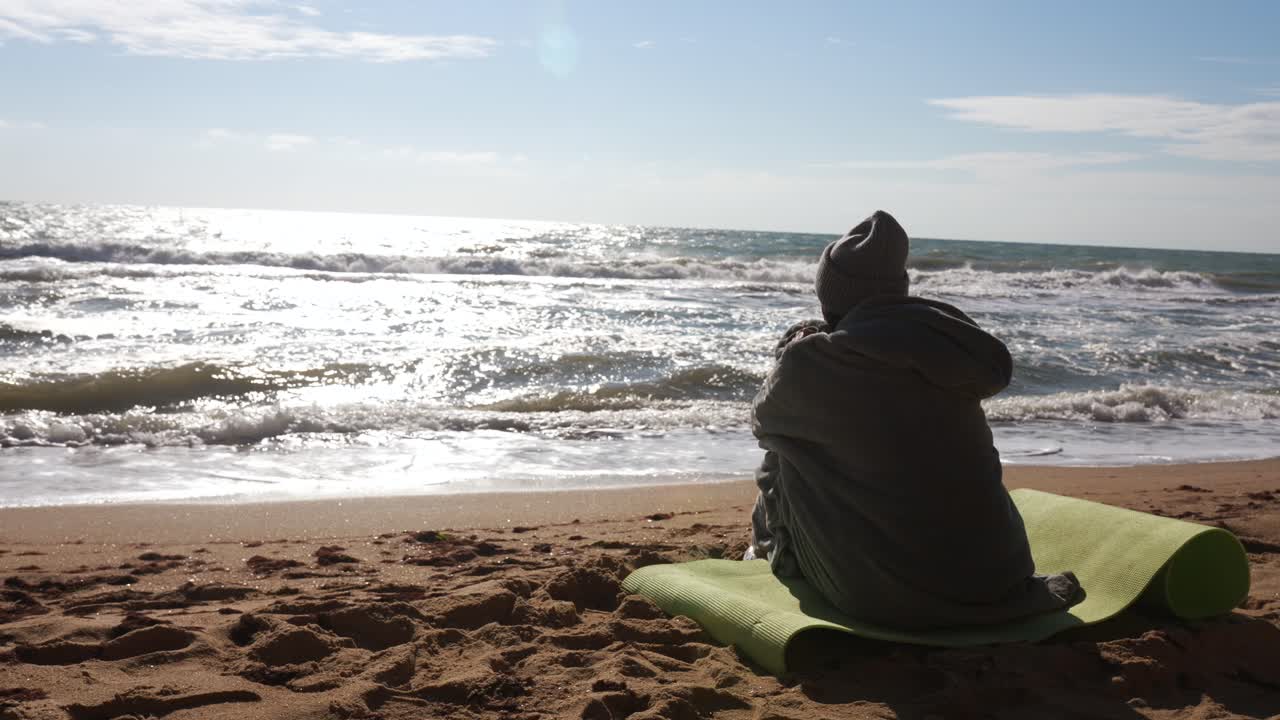 해변에 앉아서 바다를 바라보는 사람