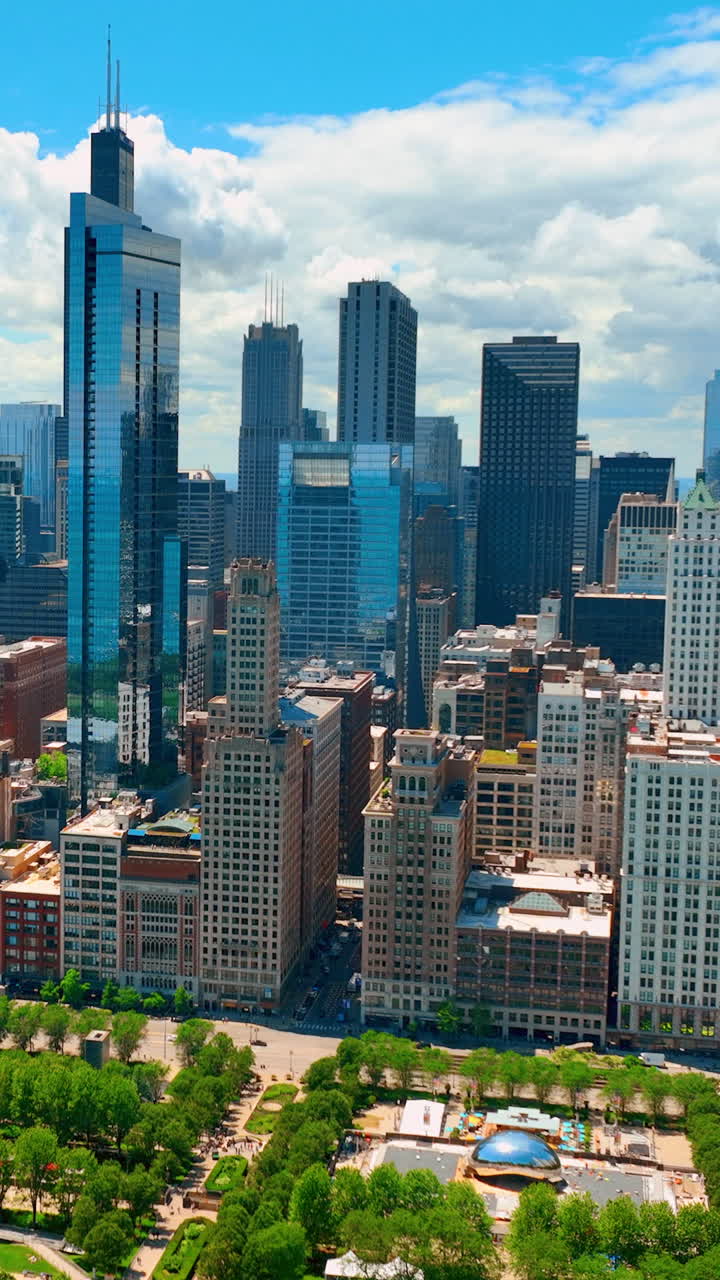 Chicago, Illinois, USA - June 01, 2024: The Bean Cloud Gate is a major city attraction. Green park and skyscrapers in the city center. Aerial view. Vertical video