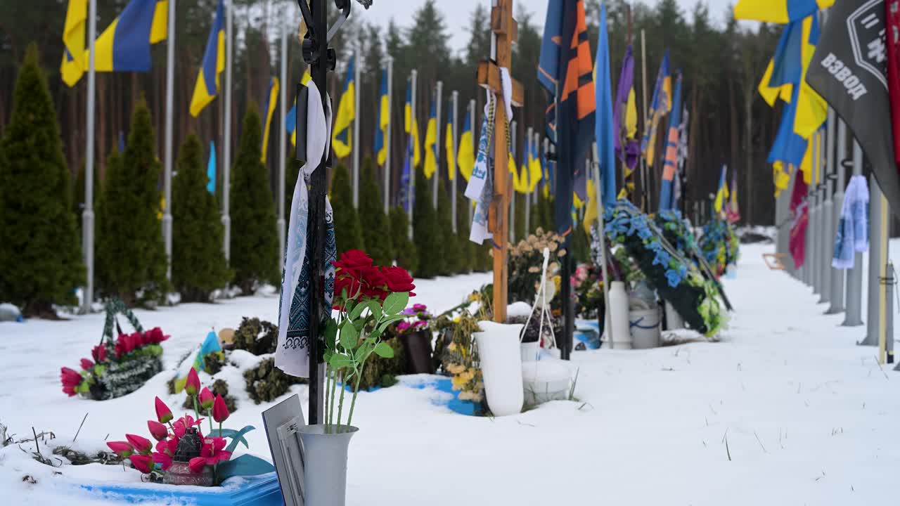 At Irpin cemetery, bouquets of flowers adorn the grave of a Ukrainian soldier, near the site of early battles in the ongoing Ukraine-Russia war, paying tribute to the fallen.