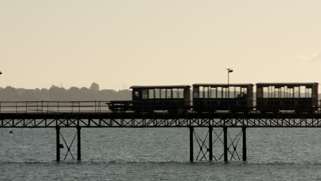 hythe pier railway train in silhouette going right to left of frame