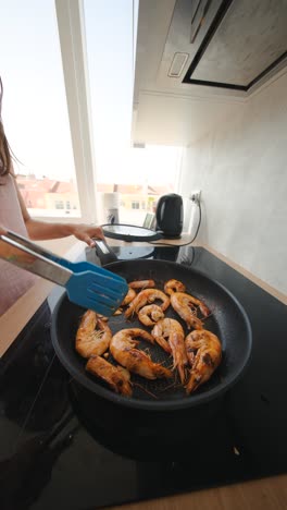 girl cooking shrimp in kitchen