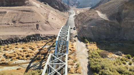 vehículos todoterreno pasando por un arroyo y un puente de armadura de tren en afton canyon, desierto de mojave, california