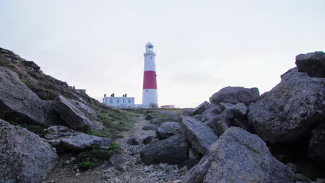 Parallax-shot-of-Portland-Bill-Lighthouse-between-the-rocks