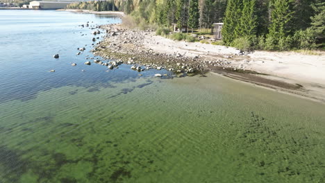 stony foreshore with crystal clear water on a calm beach in sweden