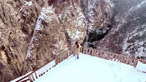 Niña-Mirando-La-Vista-En-El-Cañón,-Aumento-De-Drones,-Cañón-Kastamonu-Turquía-Valla-En-La-Temporada-De-Invierno-Cubierto-De-Nieve