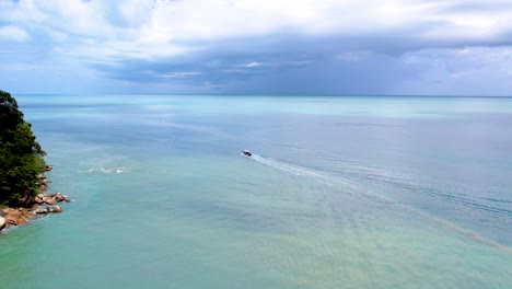 Lancha-Rápida-En-El-Océano-De-Color-Azul-Verde-En-Malasia,-Drone-Hacia-Atrás