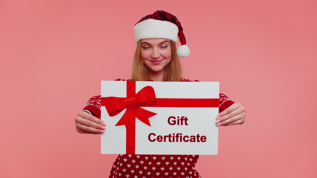 chica divertida lleva suéter rojo de año nuevo y sombrero tarjeta de presentación certificado de regalo cupón bono ganador