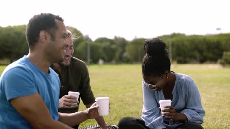 Laughing-colleagues-sitting-on-lawn-and-laughing.