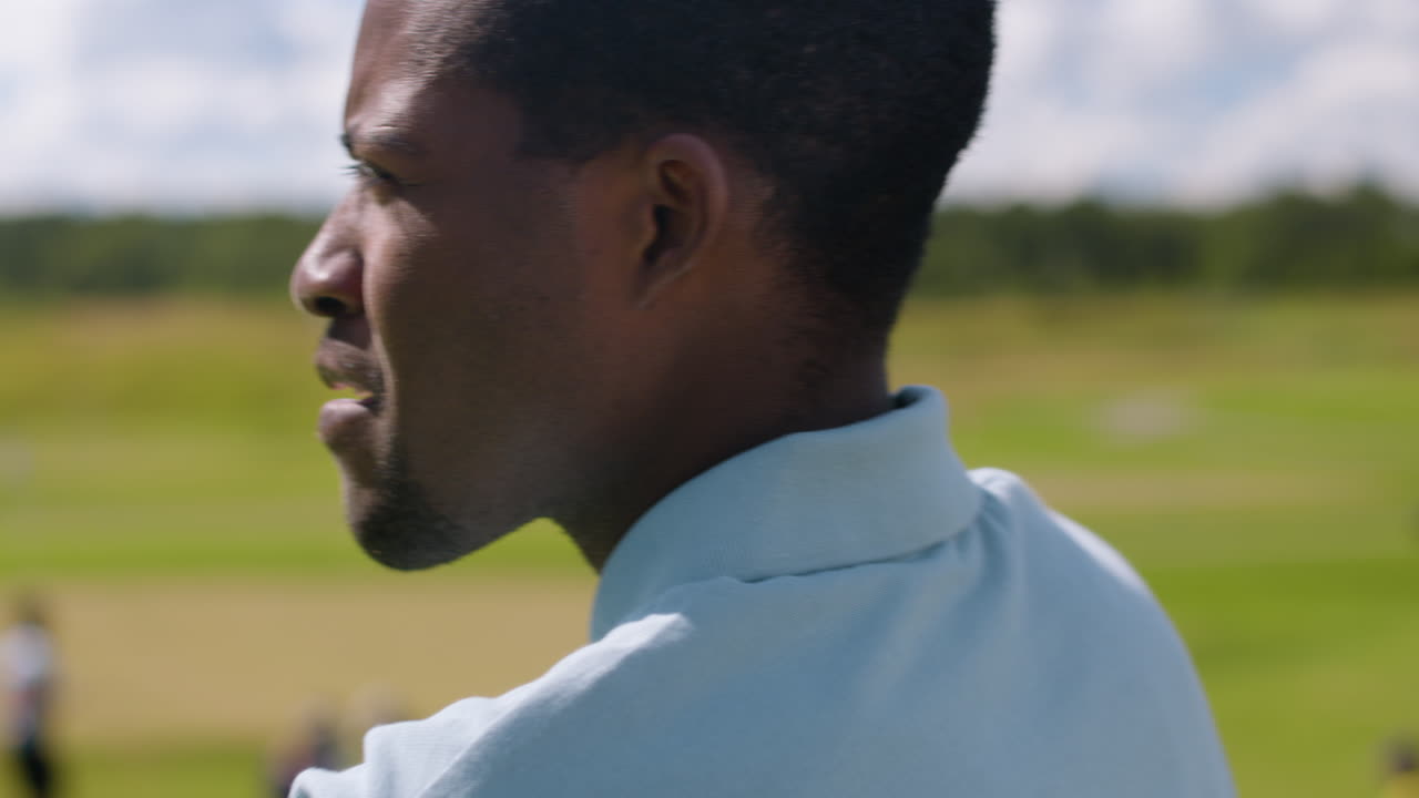 아프리카계 미국인이 골프장에서 골프를 연습하고 있습니다.