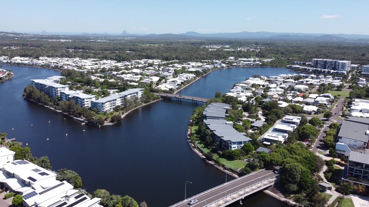 Vista aérea en 4K de canales artificiales con puentes y lujosas casas y apartamentos frente al mar en Australia