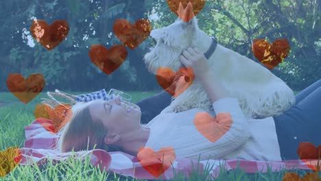 animation of red heart icons over caucasian woman with pet dog