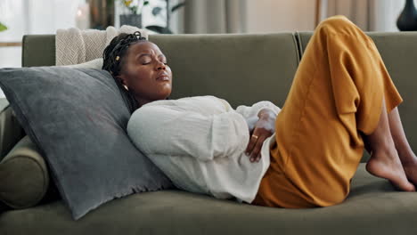 woman, stomach and sick of pain on sofa for gut