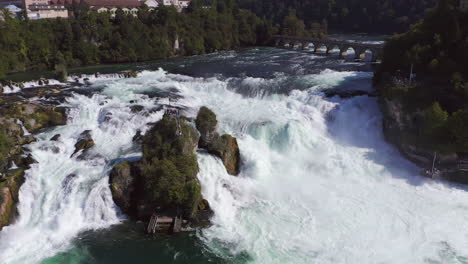 tracking shot of a rock sitting in the roaring waterfall rheinfall at schaffhausen in switzerland