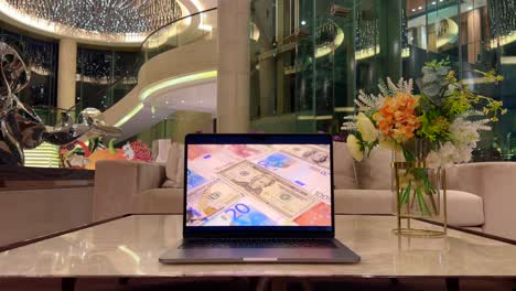 Laptop-with-American-$20-Bill-Surrounded-by-European-Bills-inside-Luxurious-Mansion