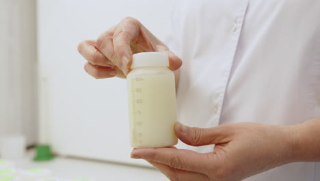 woman holding a bottle of breast milk