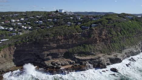 waves crashing against the cliffs in north avoca beach in central coast, nsw, australia