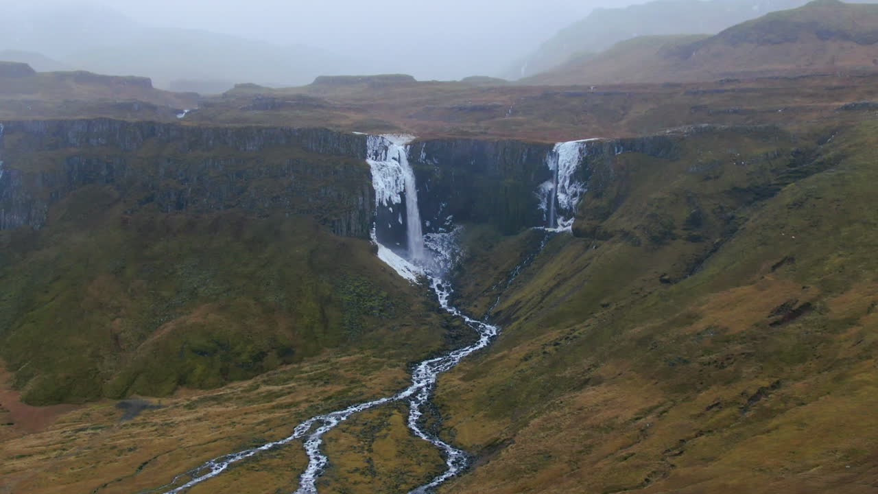 majestuosa cascada que cae en cascada en un cañón y el agua fluye en diferentes arroyos en la montaña kirkjufell de islandia cerca de grundarfjordour