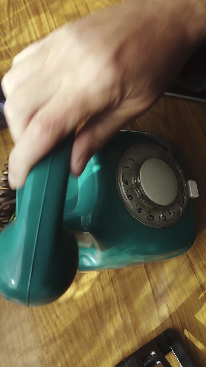 Un dito compone un numero su un telefono a disco prima di riagganciare