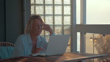 Mature-Woman-with-Laptop-on-the-Balcony