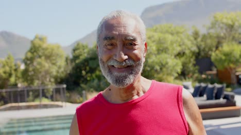 portrait of happy senior biracial man smiling in sunny garden, unaltered, in slow motion