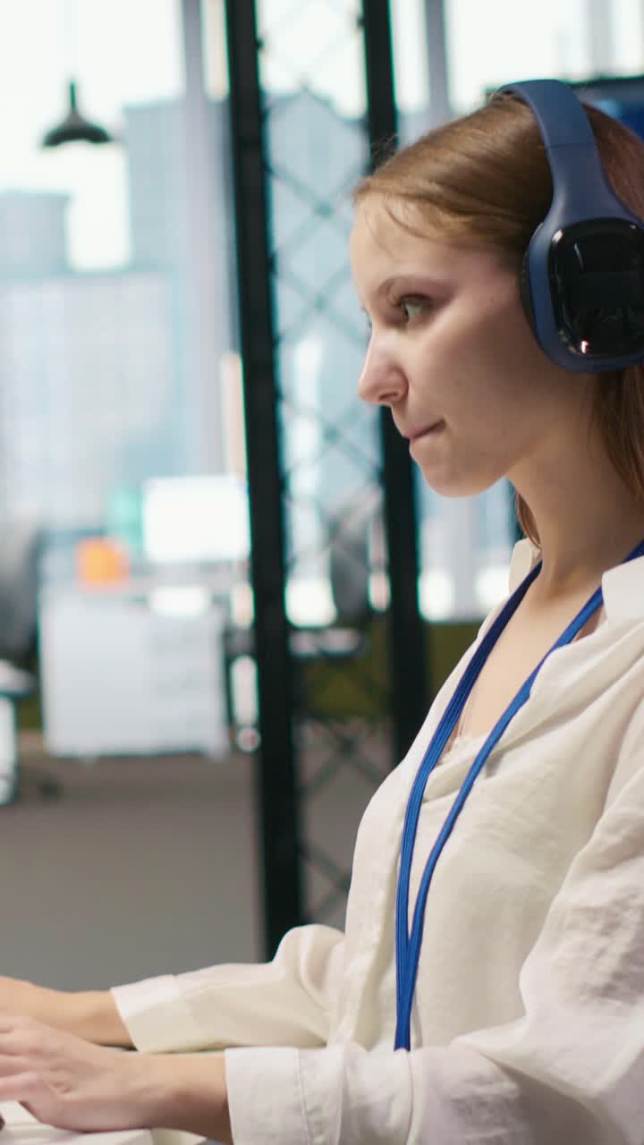 Vertical video Young female programmer in office reviewing AI system metrics, listening music