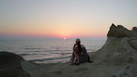 Woman-in-front-of-cinematic-sea-on-golden-summer-sunset